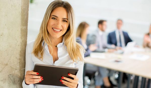 ragazza sorridente con tablet in mano a simboleggiare la digitalizzazione nelle imprese